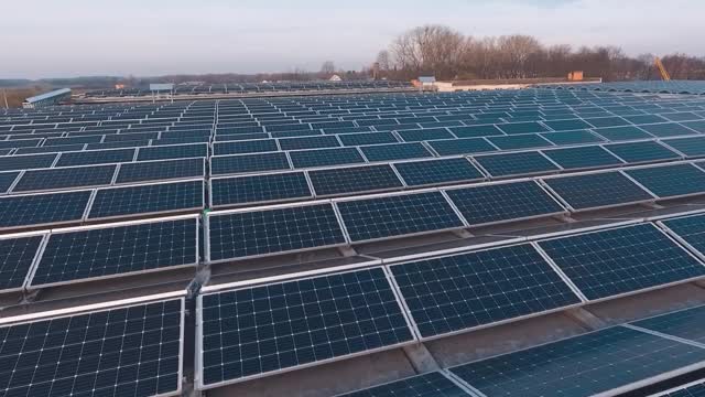 在屋顶上的现代光电板上飞行。创新的太阳能发电站与蓝色太阳能电池在阳光。生产清洁能源。视频素材