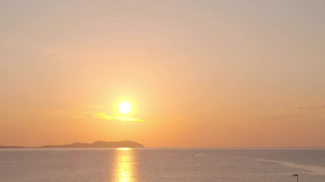 日落的时间流逝与一个岛屿在海上视频下载
