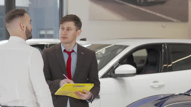 成熟的销售人员帮助男性客户选择汽车购买视频下载