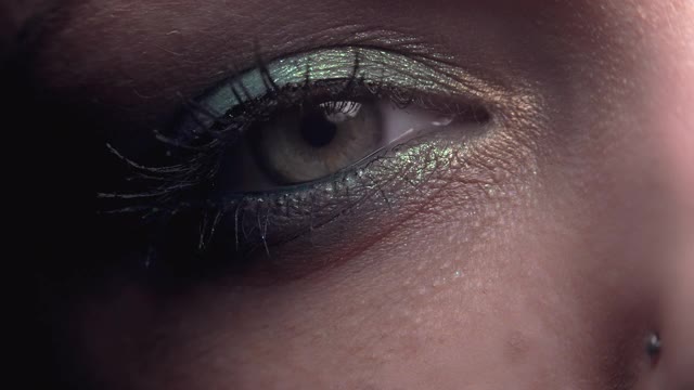 女性眨眼。漂亮的妆容，闪亮的阴影。女人的绿色眼睛收缩。美容、化妆品的概念。视频素材