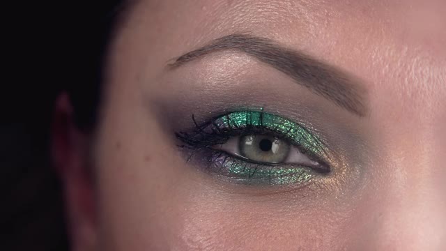 女性眼睛的特写。漂亮的妆容，闪亮的阴影。女人的绿色眼睛收缩。美容、化妆品的概念。视频素材