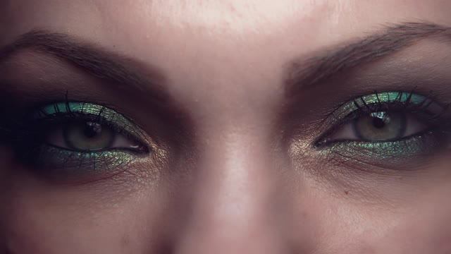 女性的眼睛。漂亮的妆容，绿色的眼影。女孩眨眼睛,收缩。美，化妆品，艺术，女性观念。视频素材