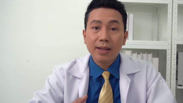 一名身穿白大褂的男性医疗助理正在视频呼叫远方的病人视频下载