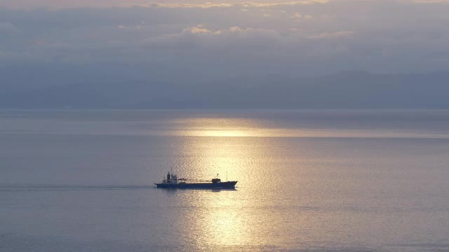 日落时海面反射的阳光下的船只(淘金)视频下载