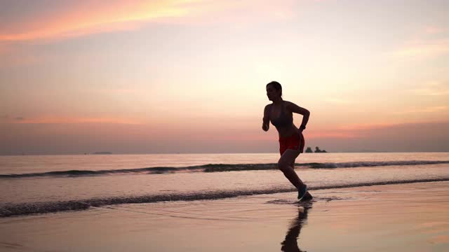 在海滩上跑步的运动女性视频下载