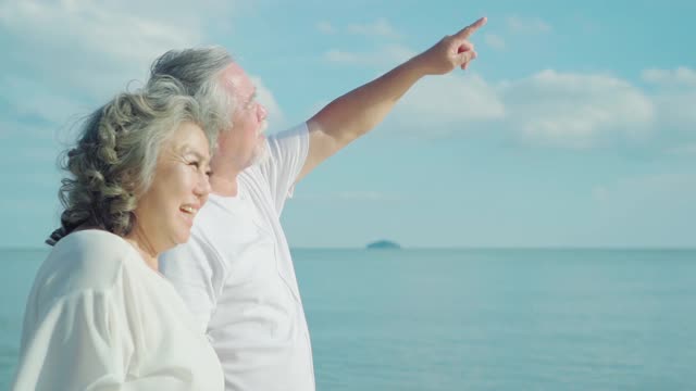 亚洲老年夫妇在海滩上的快乐时光，慢镜头。视频下载
