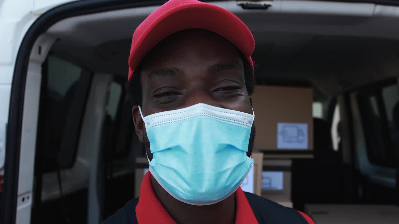 非洲男性快递员戴着防护口罩，用卡车运送包裹视频下载