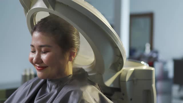亚洲华人女性在美发厅进行头发蒸润治疗视频素材