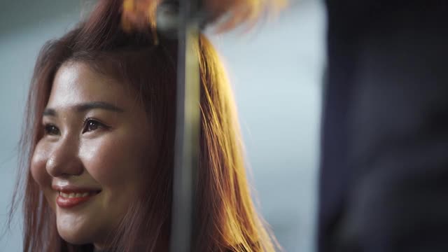 慢动作亚洲华人女性发型师在美发沙龙为她的顾客梳理湿漉漉的长发视频下载