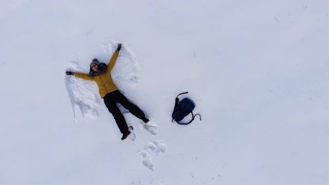 鸟瞰图女人做雪天使视频素材