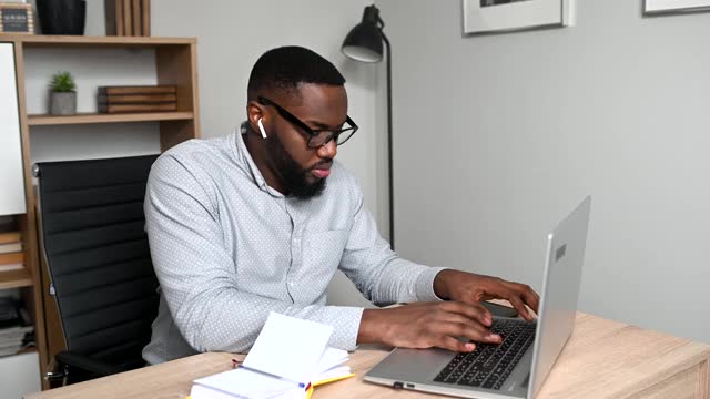 一个非洲人正在用笔记本电脑工作视频素材