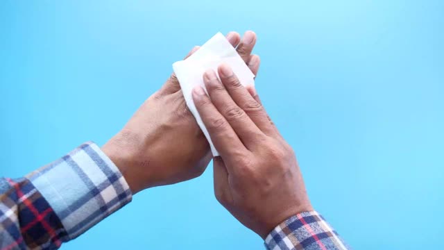 一个男人正在用湿纸巾消毒他的手。视频下载