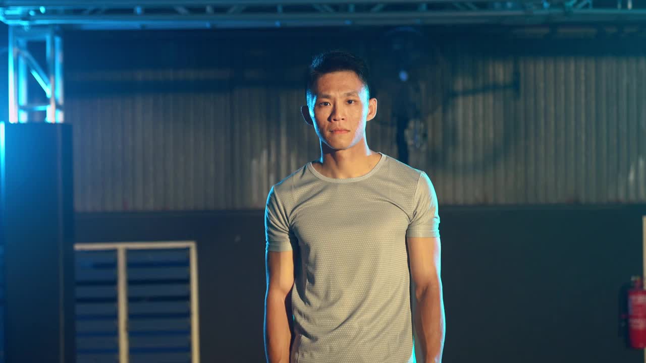 亚洲华人健身教练肖像弯曲肌肉看着镜头与冷静的态度手臂交叉视频下载