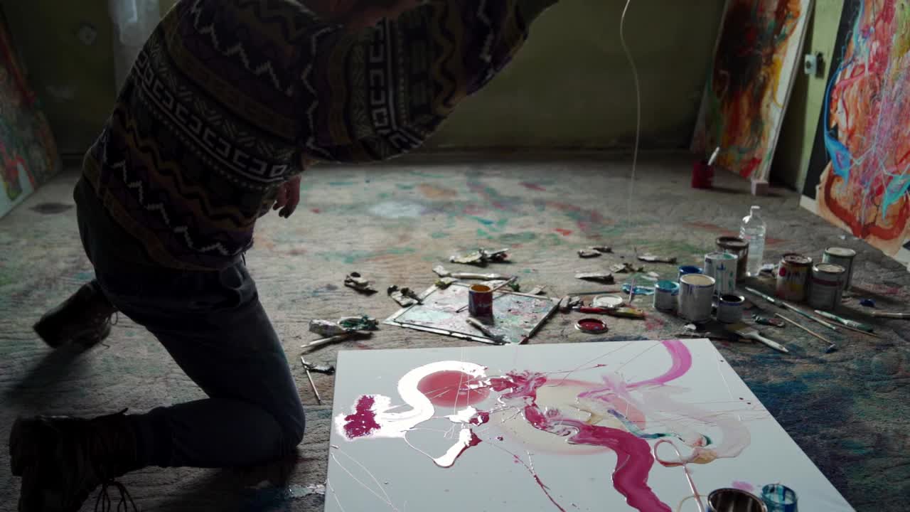 才华横溢的年轻男艺术家在他的画室的帆布上画油画视频素材