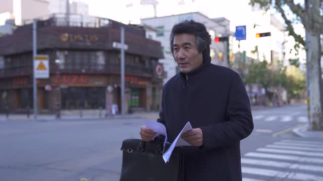 退休-中年商人做兼职工作作为路过的传单在街上视频素材