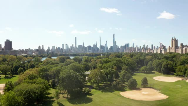 曼哈顿摩天大楼背后美丽的绿色自然与树木和湖，纽约市中央公园，空中视野视频下载