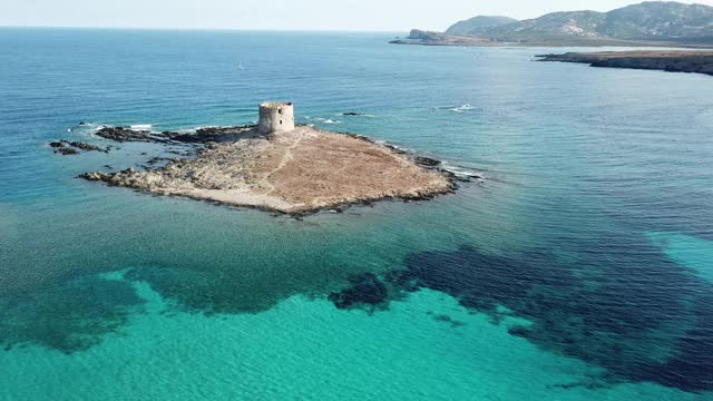 意大利撒丁岛斯丁蒂诺的拉佩罗萨海滩和猎鹰塔。鸟瞰图视频下载
