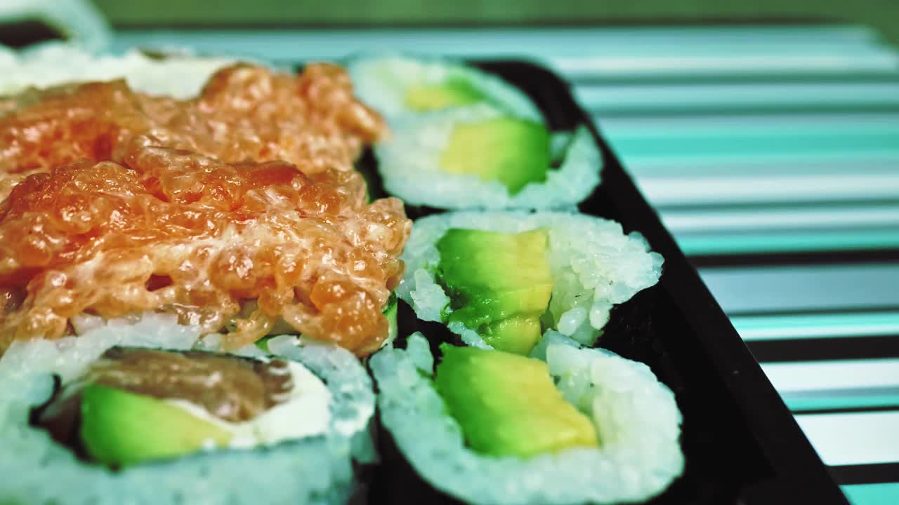 近距离观看切片寿司卷与蔬菜和鲑鱼，健康美味的素食食品。亚洲美食。自制的食物视频下载