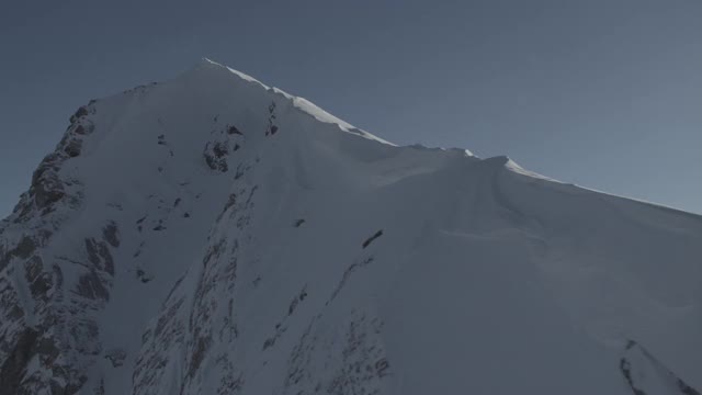无人机沿着加拿大落基山脉的雪山山脊飞行| 4K视频素材