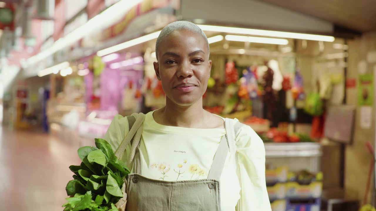 一个面带微笑的女人拿着购物袋在市场大厅视频下载