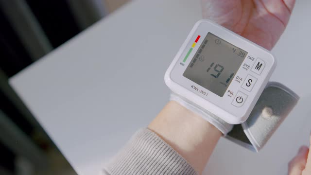 高级成人手腕监视器检查血压记录她的血压数字在笔记本上视频下载