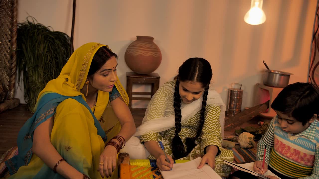 一位印度家庭主妇在帮助她的孩子们完成家庭作业视频素材