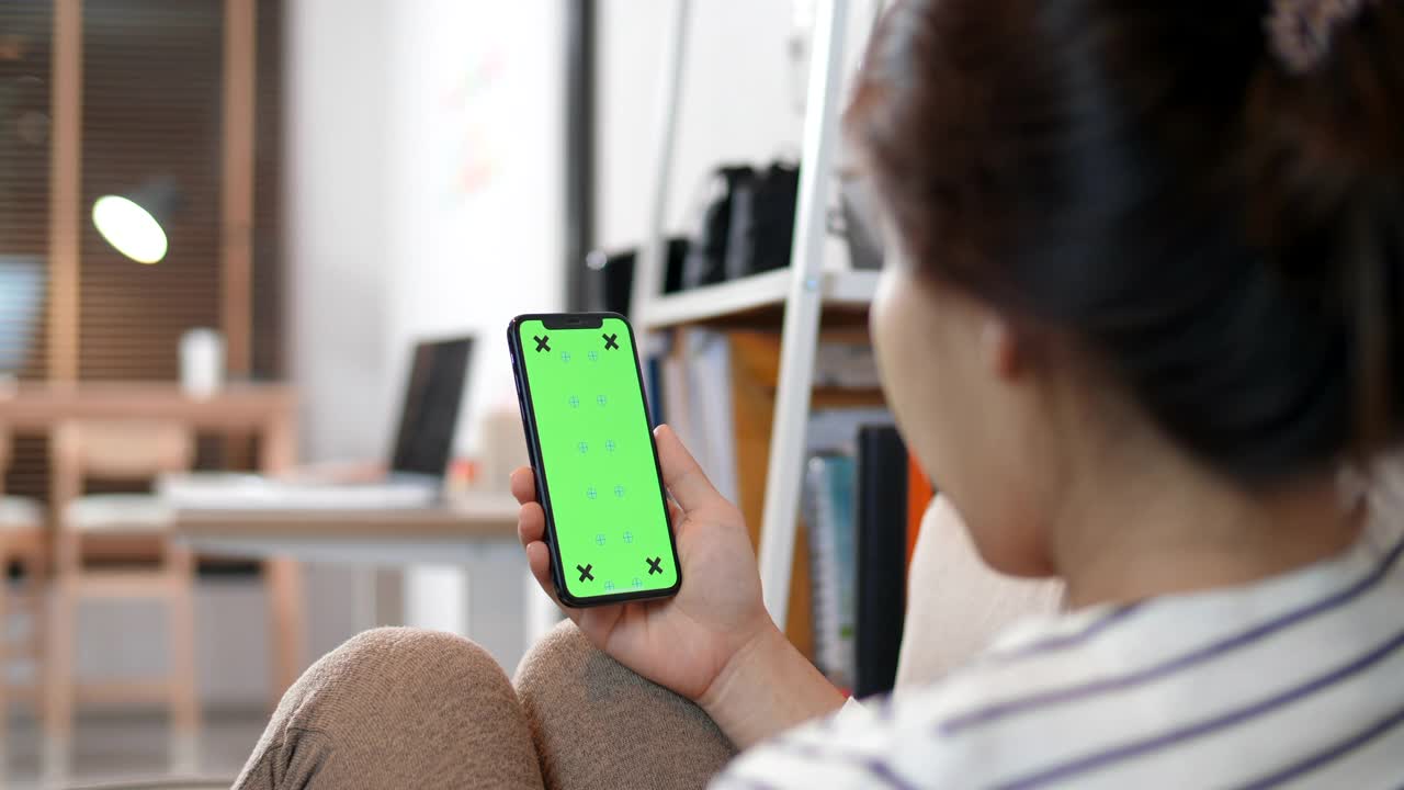女性在家里使用和使用智能手机绿色屏幕视频素材