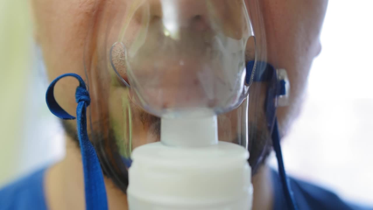 人通过吸入器面罩吸入。用于治疗肺部和支气管的吸入器。工作期间使用喷雾器服药。近距离射杀。视频素材