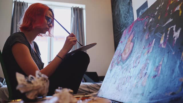 红发白人少女，艺术家，在她的房间里用油画颜料作画。视频下载