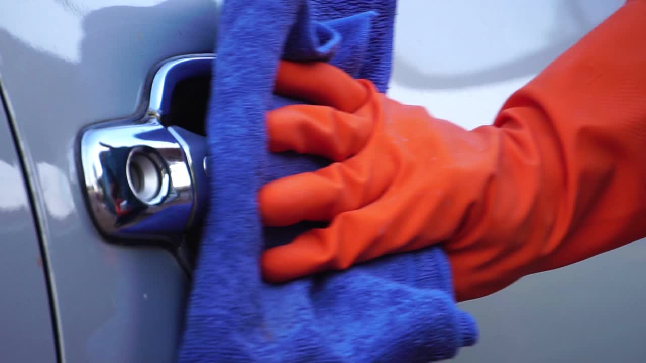 手戴手套擦拭铜车门把手表面，清洗covid-19病毒视频素材