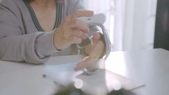 一位年长的妇女使用腕表在家测量自己的血压。视频下载