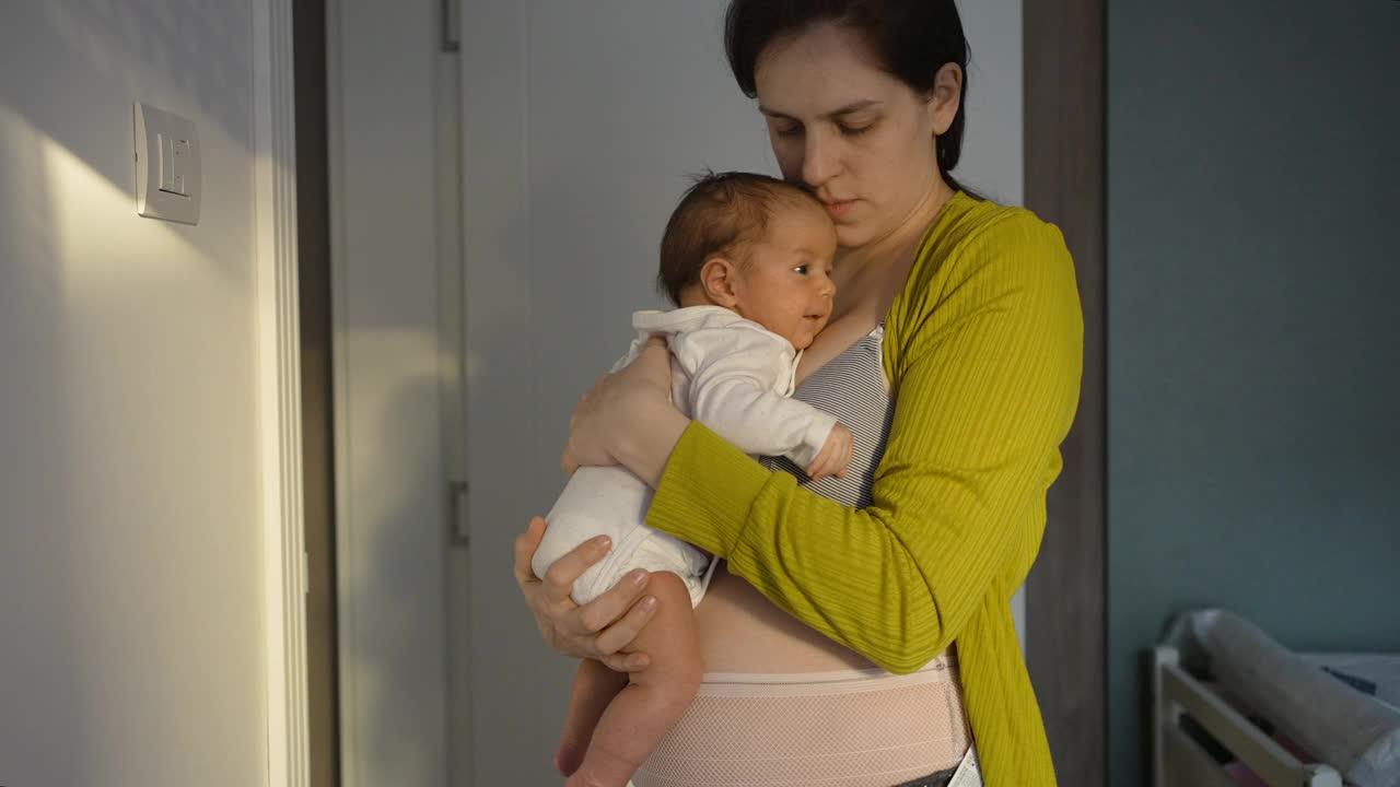 妈妈穿着产后内衣抱着刚出生的女婴视频素材