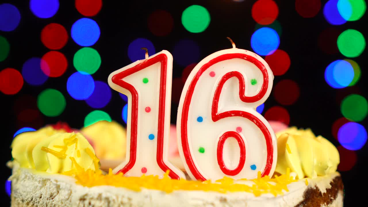 16号快乐生日蛋糕Witg燃烧的蜡烛顶部。视频下载