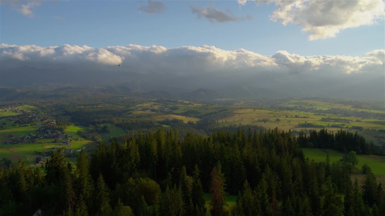 在一个阳光明媚的日子，从上面俯瞰远处的塔特拉山脉全景视频下载