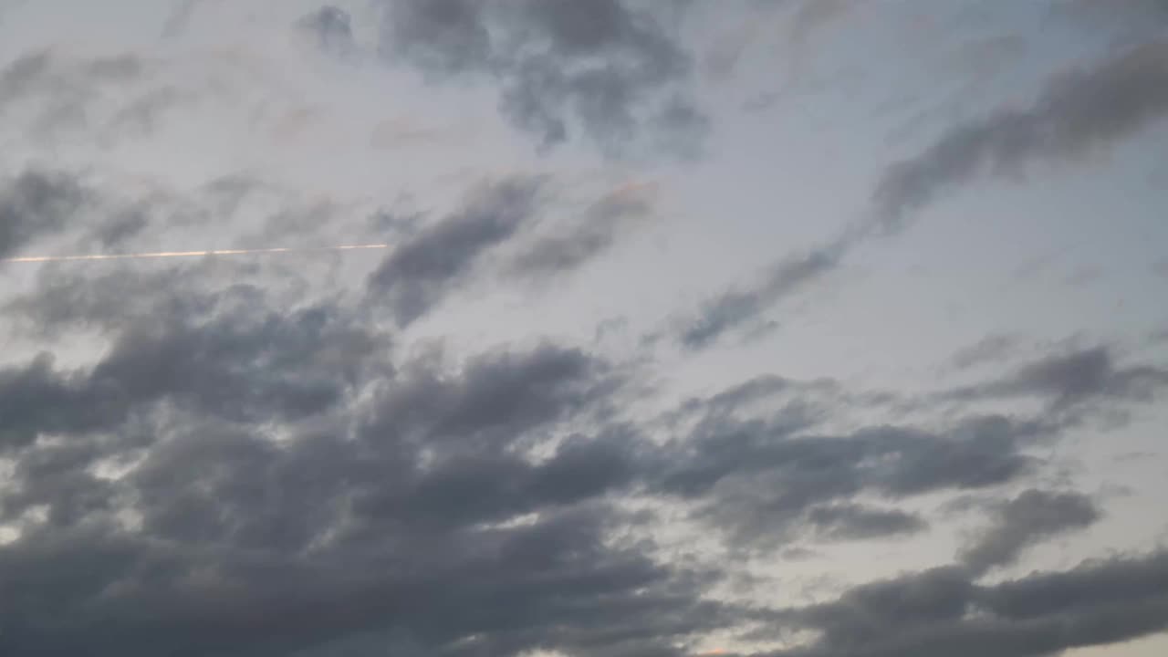 运动中的云和一架飞机的时间流逝视频下载