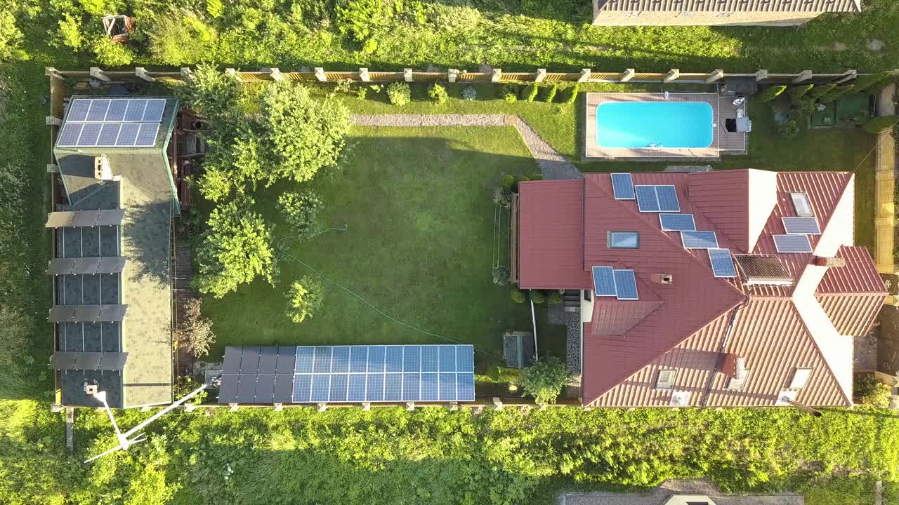 屋顶上有太阳能电池板和风力发电机涡轮机的自主房屋鸟瞰图，以生产清洁廉价的电力。视频素材