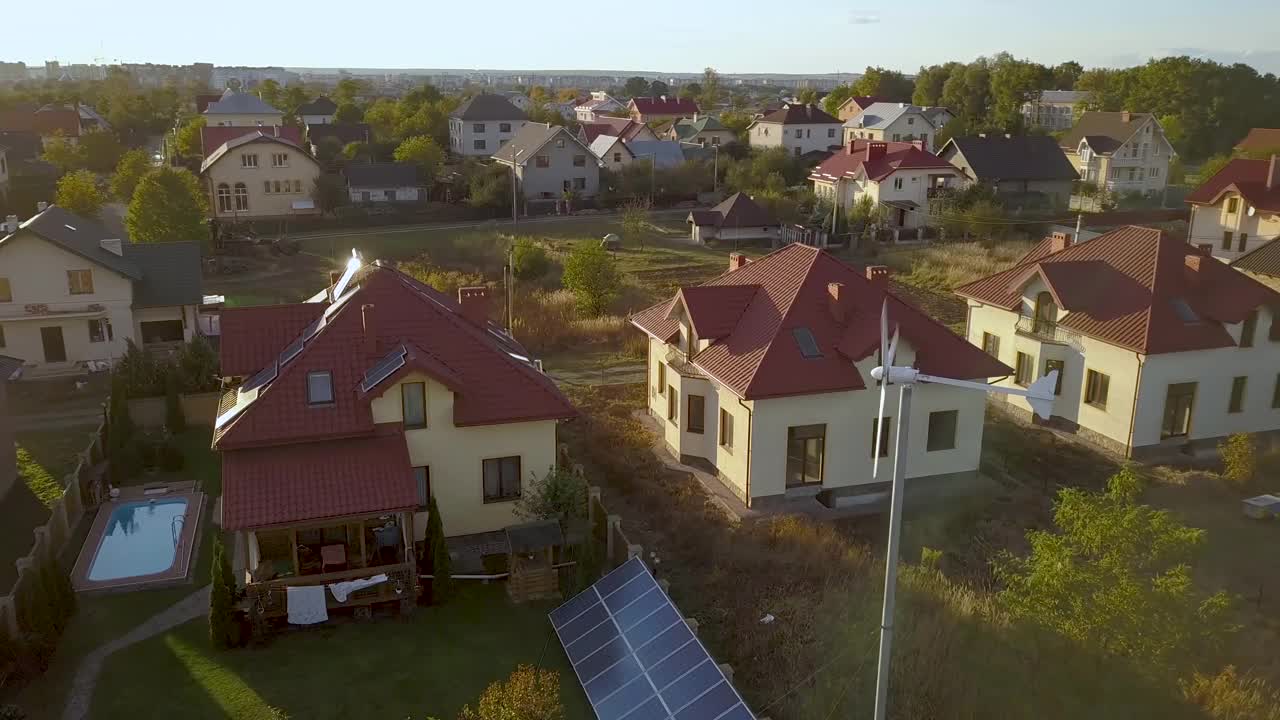 住宅私人住宅的鸟瞰图，屋顶上有太阳能电池板和风力发电机涡轮机。视频素材
