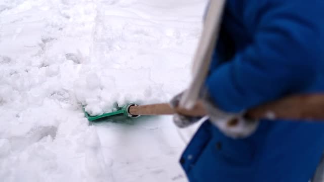 小男孩在冬天铲雪。视频下载