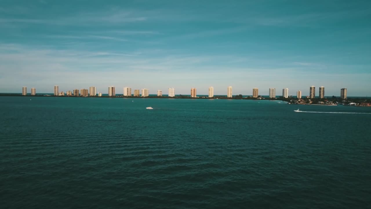无人机拍摄的佛罗里达北棕榈滩的蓝绿色入口后面的建筑，望向辛格岛，佛罗里达视频下载