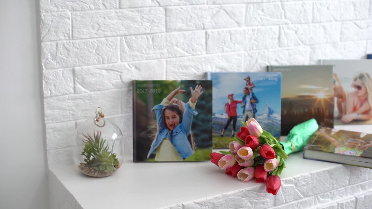 书架上放着相册和鲜花，还有作为节日礼物的郁金香视频下载