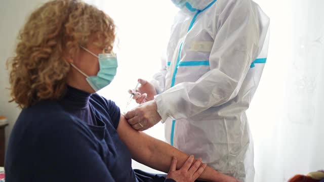 医生在病人家里给病人接种新冠病毒疫苗视频素材