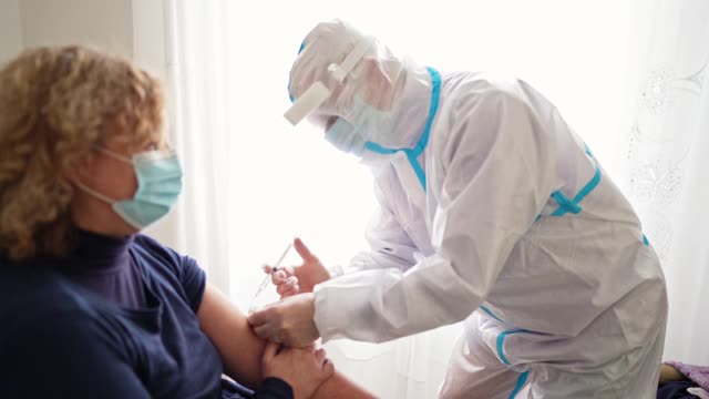 医生在病人家里给病人接种新冠病毒疫苗视频素材