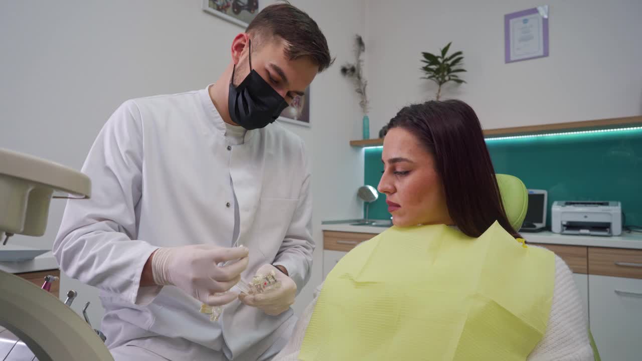 牙医向他的女病人讲解牙齿美白的方法视频下载