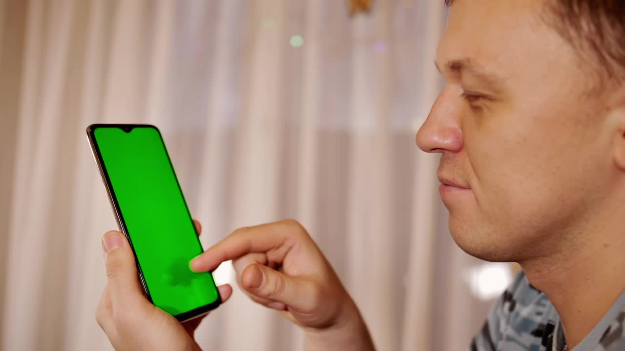 一个年轻人的侧面与手机在他的手，铬键视频素材