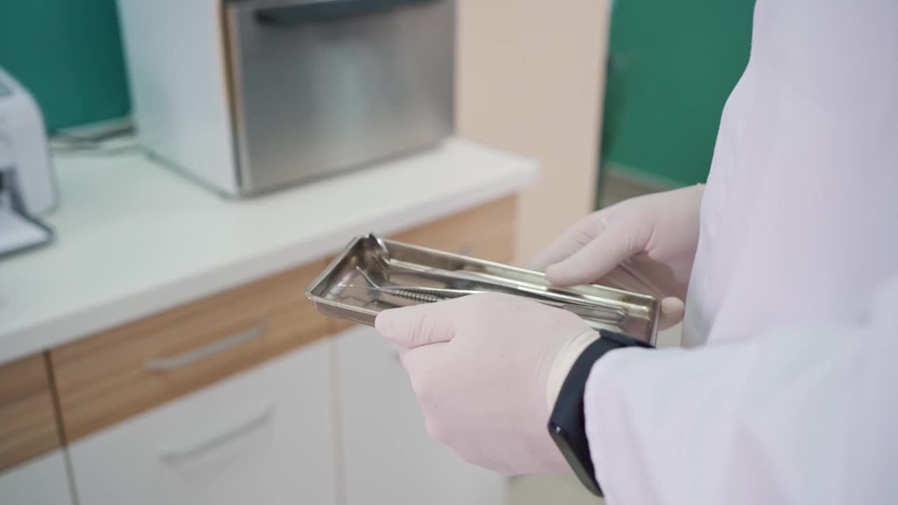 牙科医生将装有牙科器械的金属托盘放入高压釜内消毒视频下载