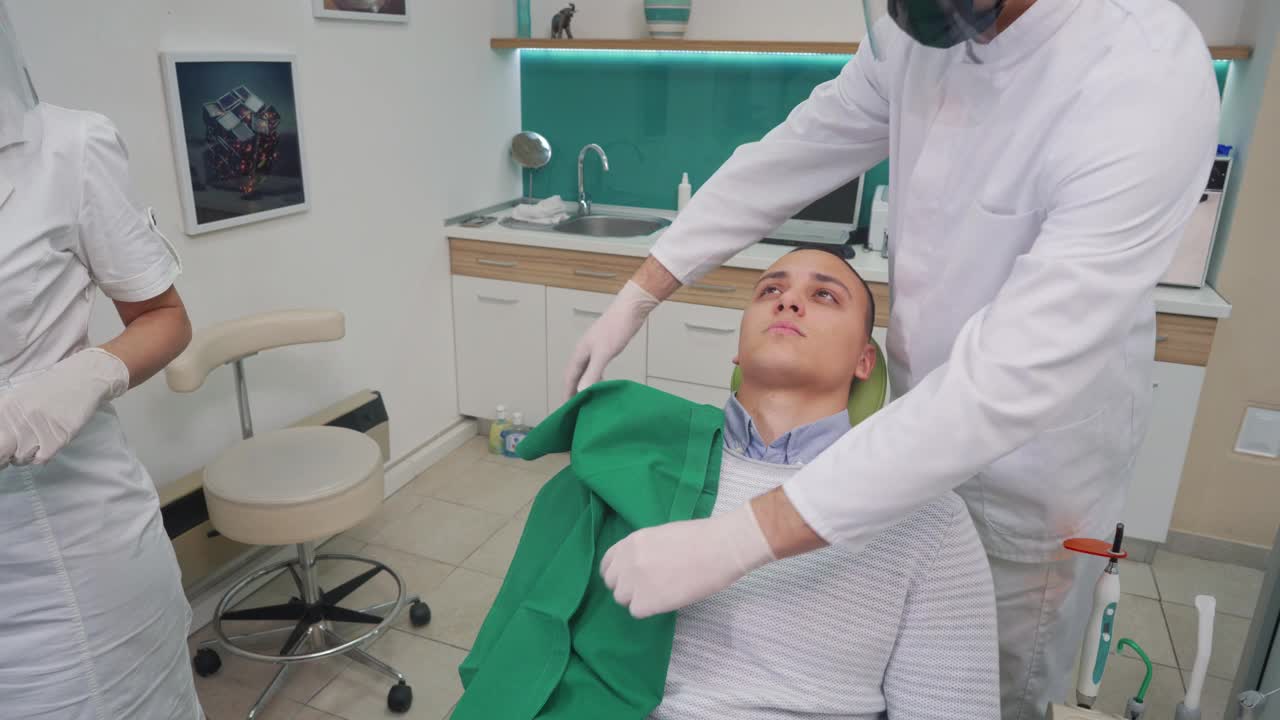 牙科医生在开始做口腔手术前先盖住病人头部视频素材