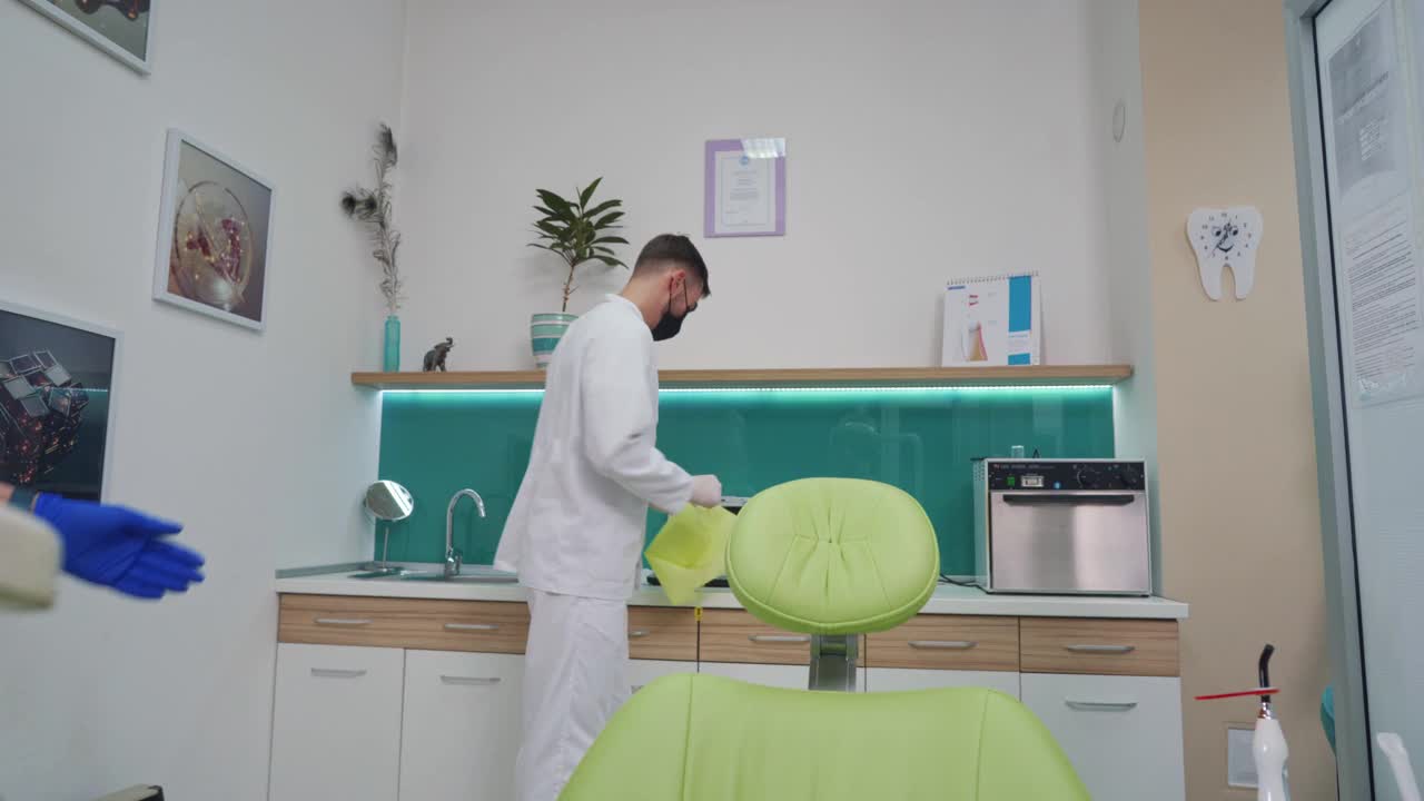 牙科医生在一个十几岁的病人开始看牙医之前给他敷上防护布视频下载