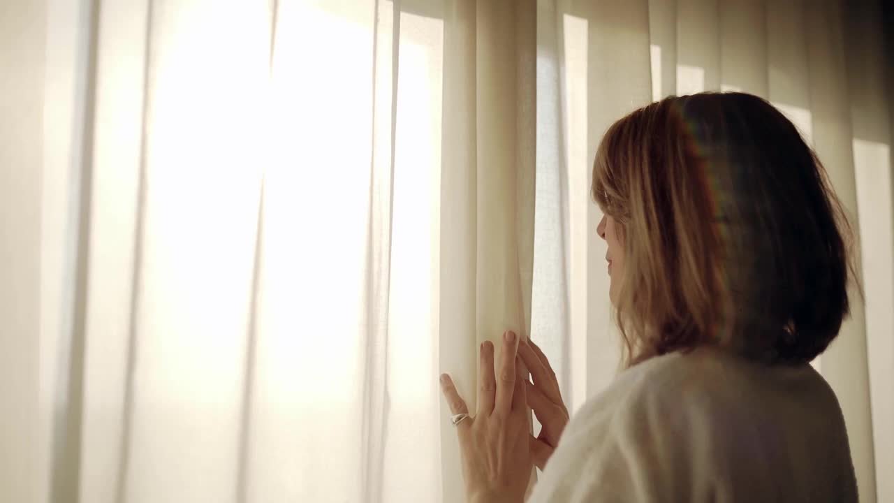 一个女人在豪华酒店房间打开白色窗帘视频下载