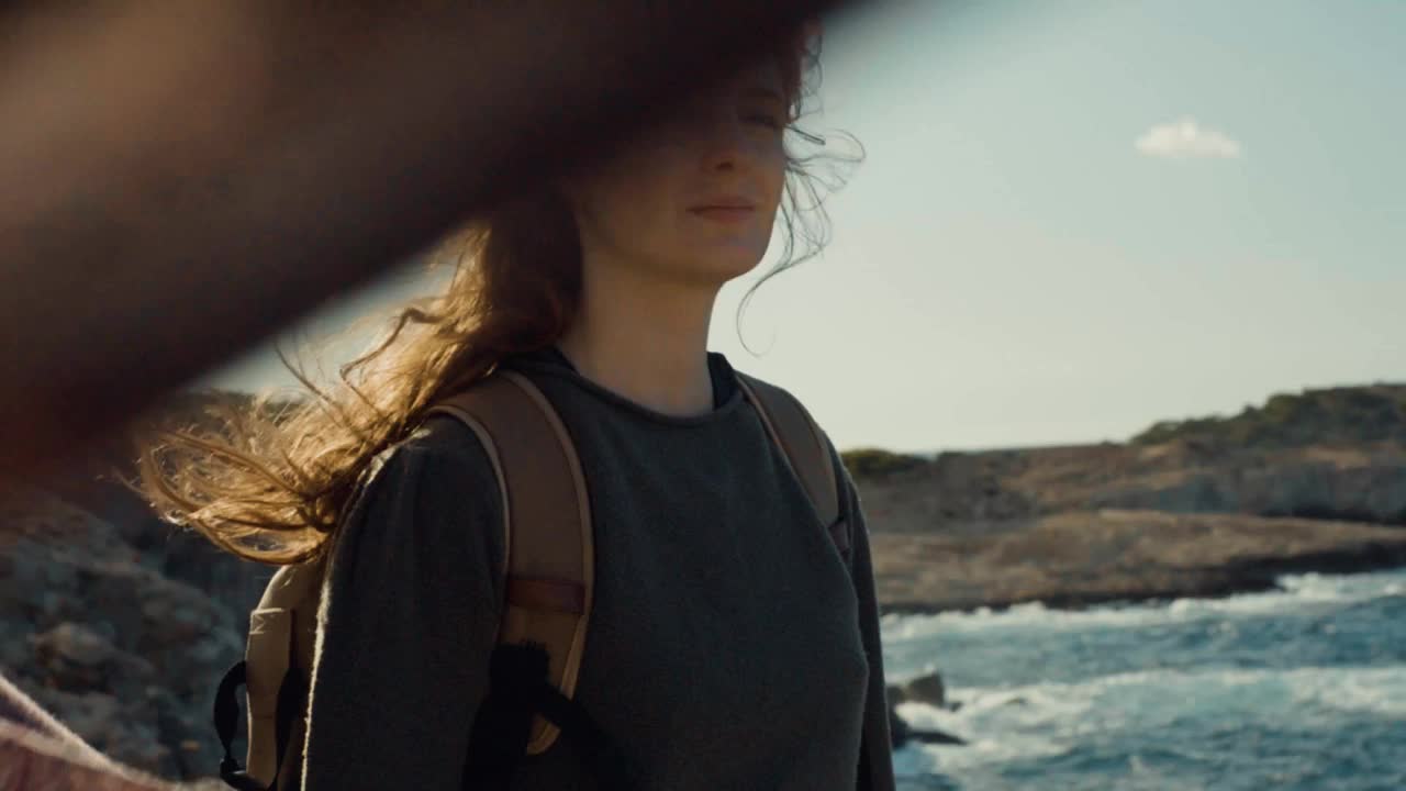 一个快乐的红发女人拿着一块布在海边的慢镜头视频下载