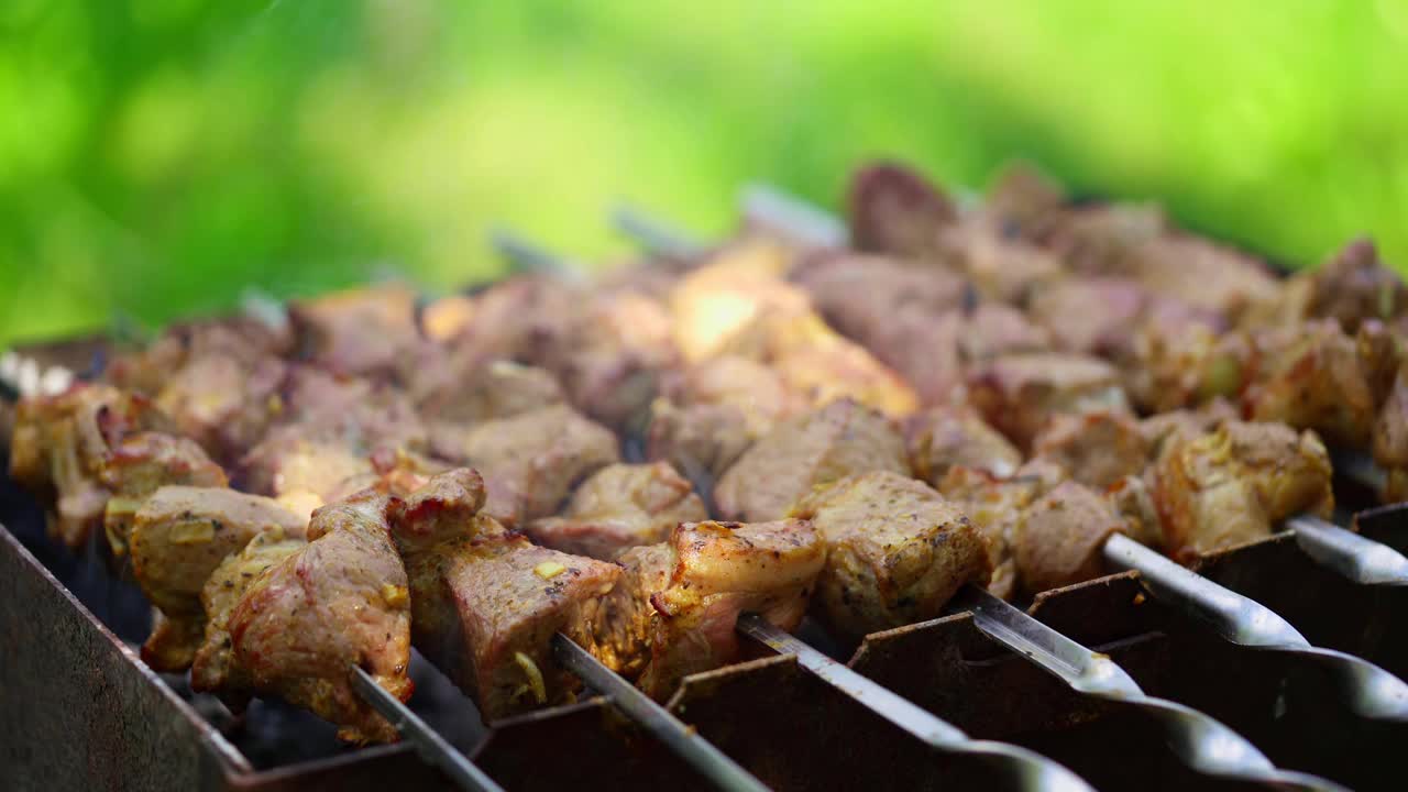 美味的烤肉串在户外。准备烧烤猪肉。绿色背景上的mangal烤肉串。视频素材